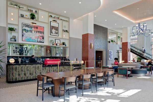 Verve Ann Arbor modern coffee shop with a long communal table, barista counter, and people working on laptops in a bright space.