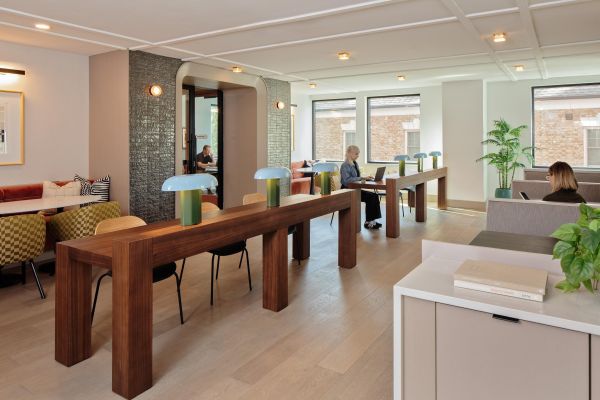 Verve Ann Arbor modern co-working space with long wooden tables, people working on laptops, and large windows.