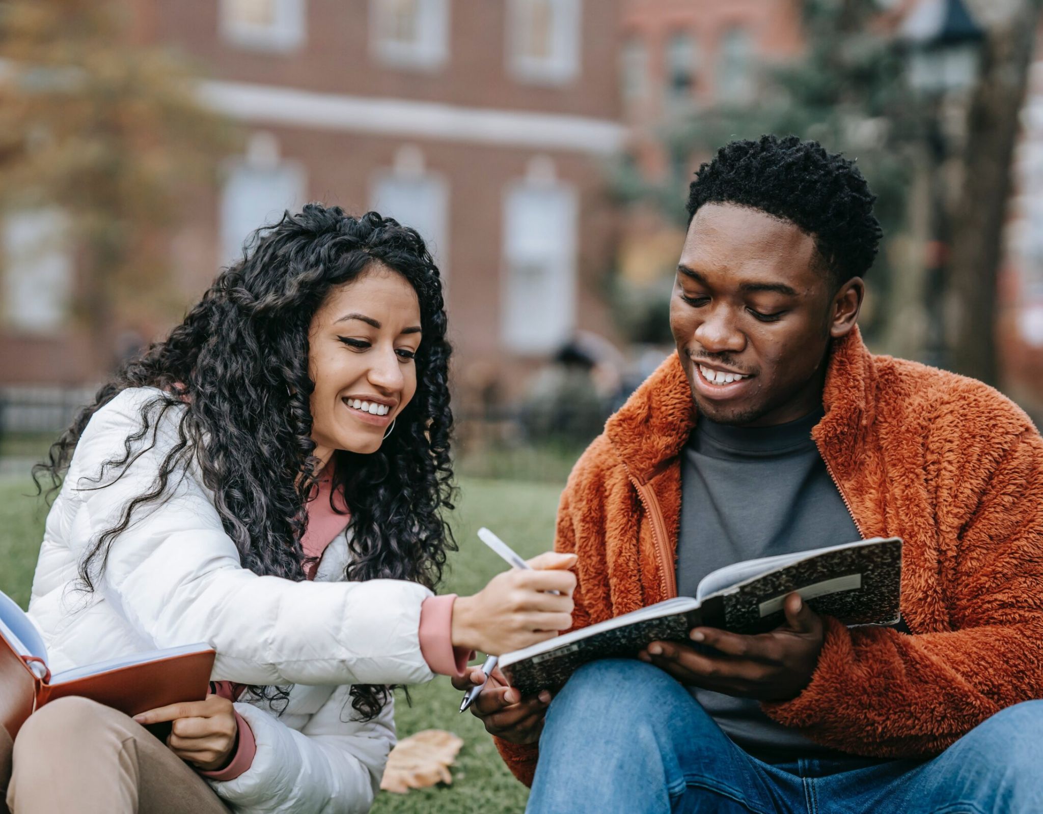 Two college aged students writing new year's resolutions.