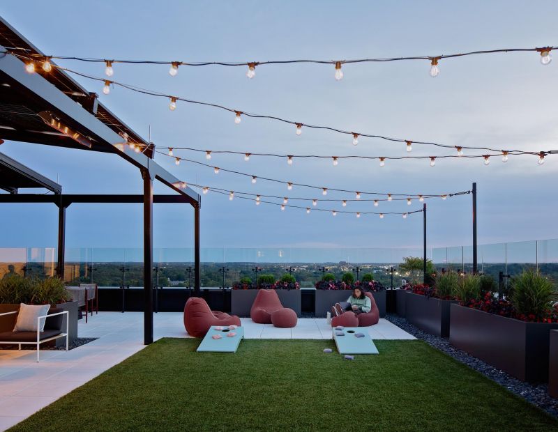 Rooftop patio with lounges and games for relaxing.